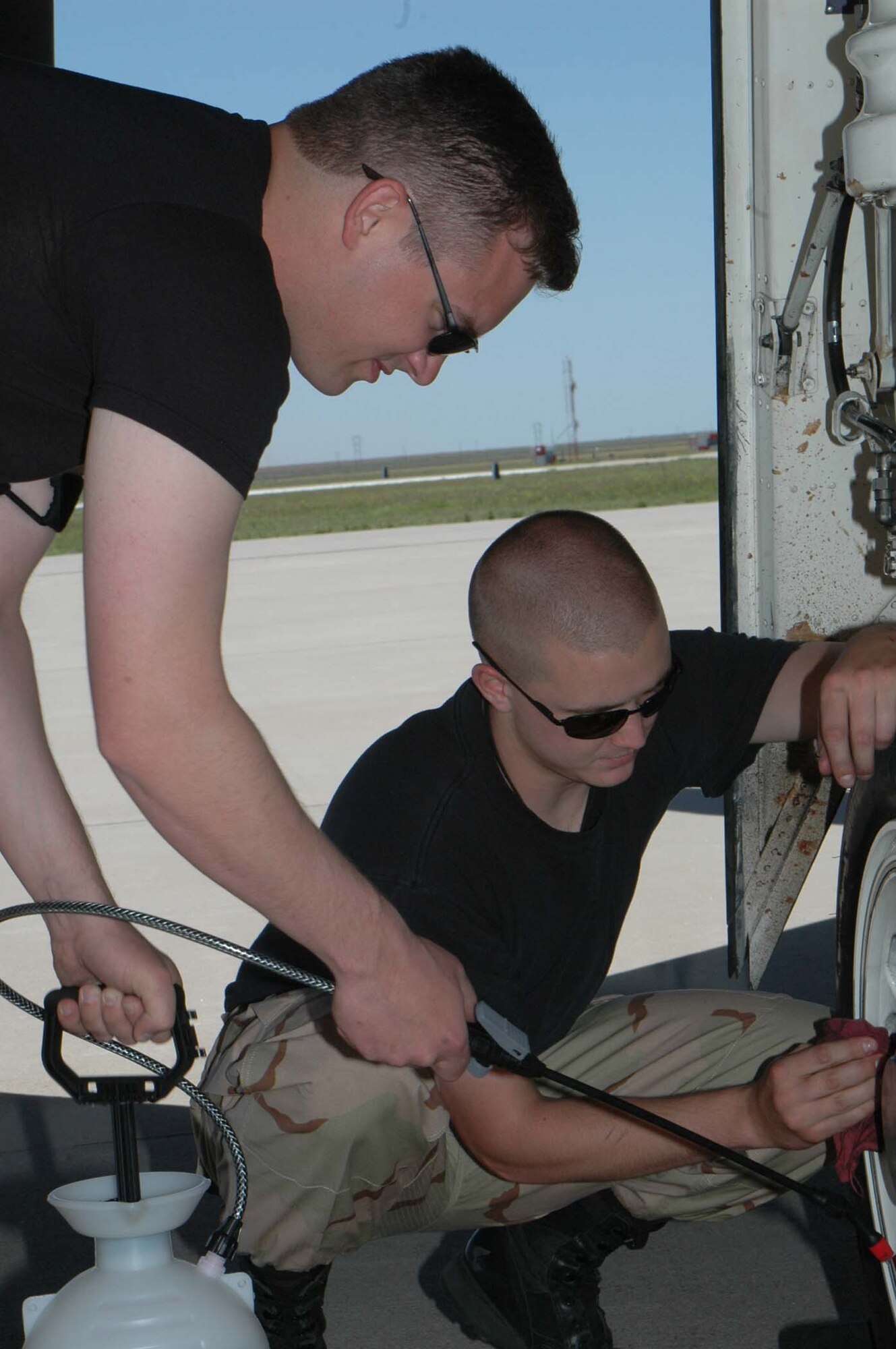 Senior Airman Christopher Robinson and Staff Sgt. Benjamin Youngs, both of the 49th Aircraft Maintenance Squadron, clean the wheels of the F-117A Nighthawk in order for the aircraft to look good during the weapons load competition June 8. Twenty five Airmen traveled to Cannon Air Force Base, N.M., for the event where the team took first place. (U.S. Air Force photo/Airman 1st Class Heather Stanton)
