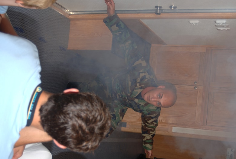 Staff Sgt. Darnell Strauheim, 14th Civil Engineer Squadron, demonstrates fire prevention techniques Friday to a group of youth. CAFB has recently received a Fire Prevention Trailer to educate the BLAZE Team on the best ways to react during a houshold fire. (U.S. Air Force Photo by Airman 1st Class Danielle Powell)