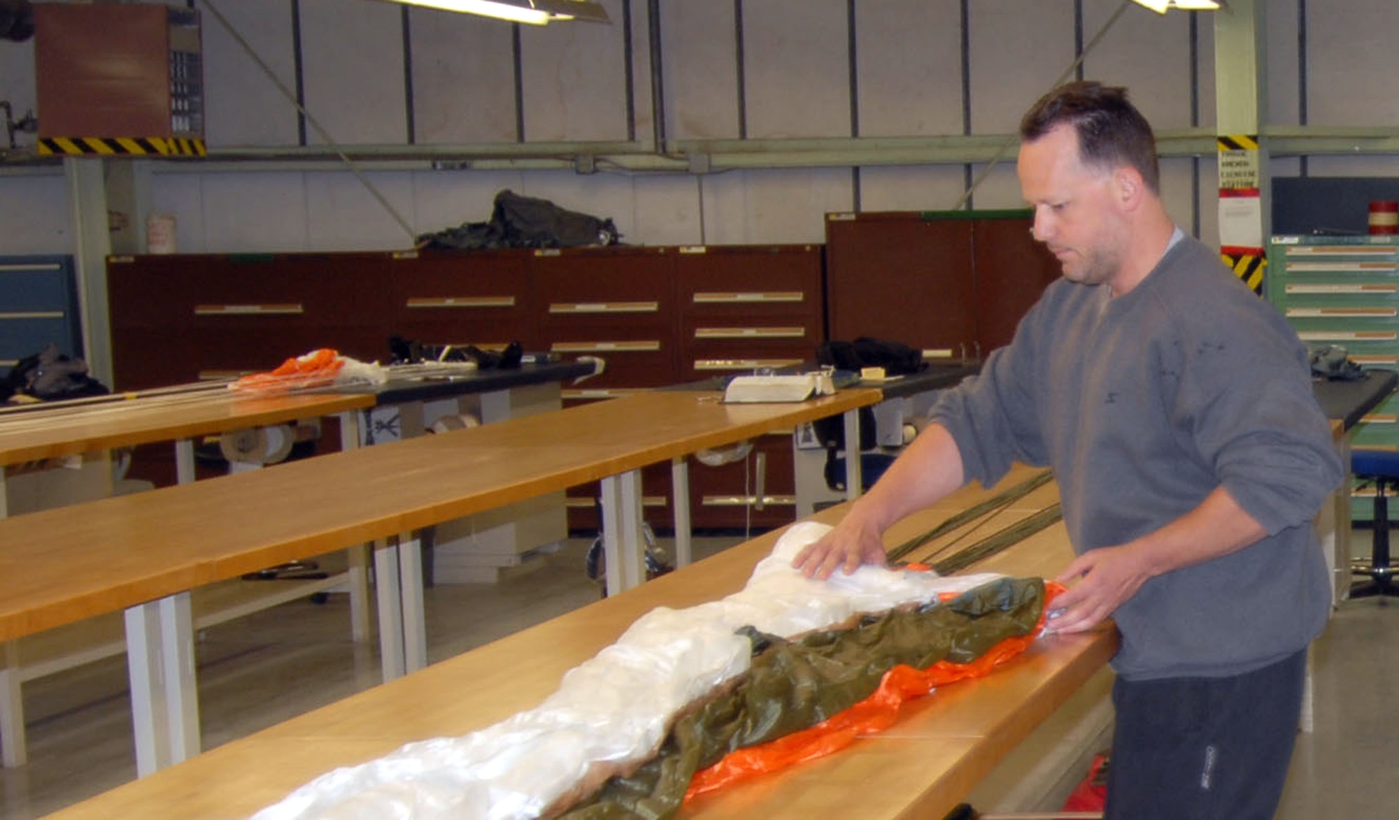 Richard Micalizzi, 412th Maintenance Squadron parachute rigger, repacks a parachute. (Photo by Airman Mike Young)