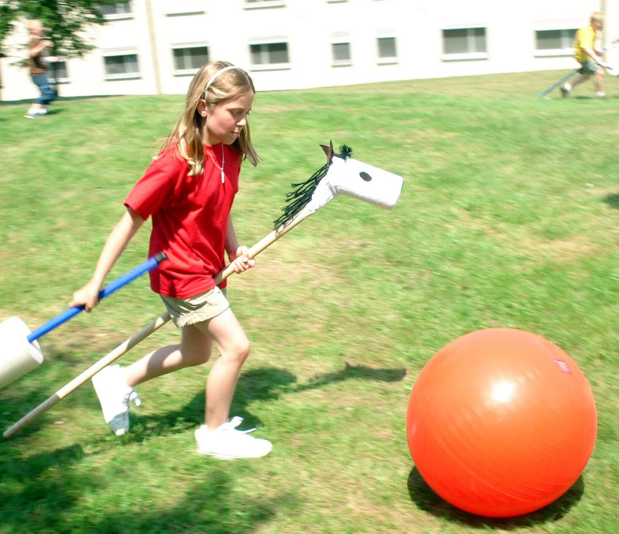 SPANGDAHLEM AIR BASE, GERMANY -- Haylie Hamblin, a Bitburg Elementary School student, jousts while visiting “Manderscheid” during the BES volksmarch activity trail at the Bitburg Annex. The students followed a volksmarch trail around the base with nine stations representing different local cities. At the stations children read information about the town and upcoming summer events. The students also participated in relay races, suitcase relay, tug-of- war and sack races. Haylie is the daughter of Staff Sgt. Darrin Bang, 52nd Aircraft Maintenance Squadron. (Photo by Dr. Sue Kerns)