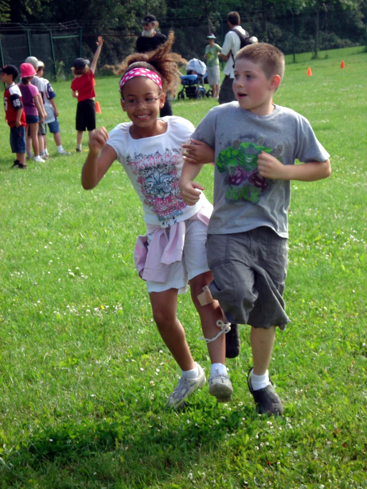 SPANGDAHLEM AIR BASE, GERMANY -- Bitburg Elementary School students Brooke Murray and Jacob Hitchcock run the three legged race event during a field day event. The students followed a volksmarch trail around the base with nine stations representing different local cities. At the stations children read information about the town and upcoming summer events. The students also participated in relay races, suitcase relay, tug-of- war and sack races. Brook is the daughter of Staff Sgt. Meghan Meyer, 52nd Maintenance Operations Squadron. Jacob is the son of Tech. Sgt. Matthew Hitchcok, 52nd Civil Engineering Squadron. (Photo by Dr. Sue Kerns)