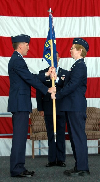 Col. Scott Vander Hamm, 28th Bomb Wing commander, presents Col. Naomi Boss, 28th Medical Group commander, the medical group flag during a change of command ceremony here June 4. Colonel Boss has been on active duty since 1981 and is now responsible for ensuring maximum wartime readiness by operating a community-based healthcare system maintaining the health and morale of Air Force members through accessible, quality medical and dental care for about 13,600 beneficiaries. (U.S. Air Force photo/Tech. Sgt. Todd Wivell)