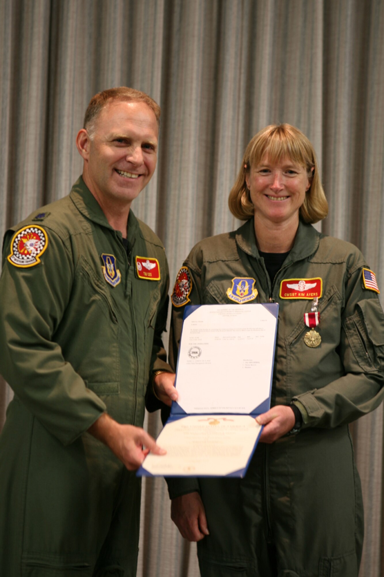 GRISSOM AIR RESERVE BASE, Ind., -- Lt. Col. Timothy Cox, the commander of the 74th Air Refueling Squadron, presents a retirement certificate to Chief Master Sgt. Kim Ayers, the Inflight Refueling Superintendent for the 74th Air Refueling Squadron. Chief Ayers served for 32 years in the Air Force prior to her retirement.(U.S. Air Force photo/Senior Airman Omar Delacruz)