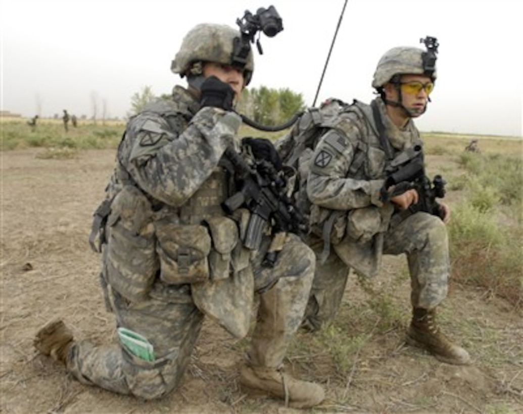 Army 1st Lt. Britt Cleveland (left) radios in details on the discovery of improvised explosive devices in the area of Mahmudiyah, Iraq, on June 3, 2007.  Cleveland is assigned to Alpha Battery, 2nd Battalion, 15th Field Artillery, 2nd Brigade Combat Team, Fort Drum, N.Y.  