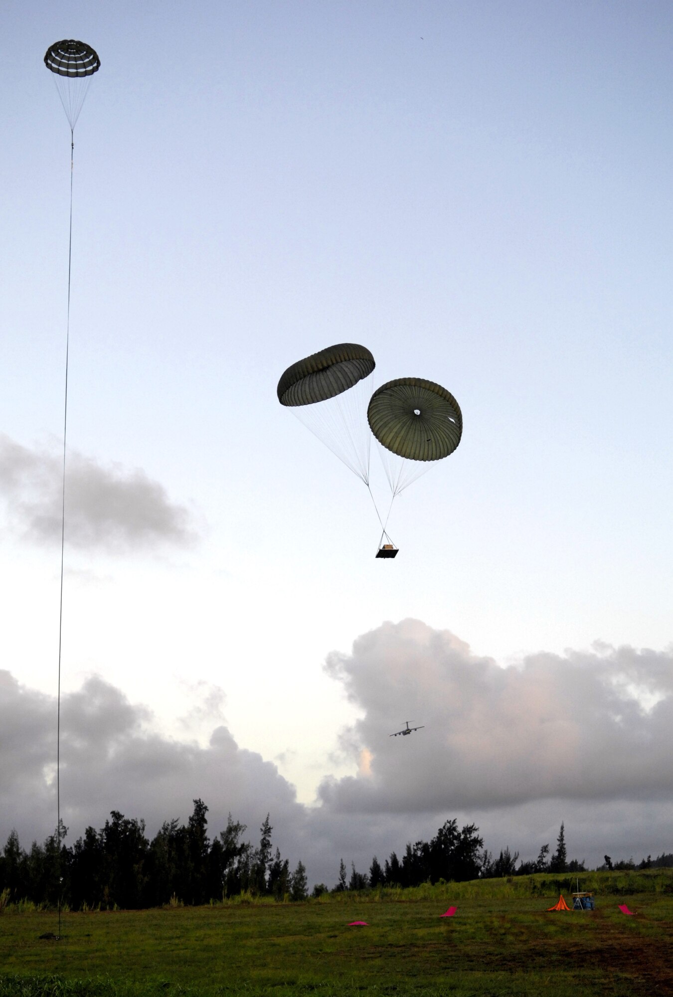 Practice airdrop bundles come in for a landing at the Kahuku Training Range in Hawaii Monday. The C-17’s, from the 535th Airlift Squadron, Hickam Air Force Base, Hawaii are conducting their quarterly airdrop qualifications. (U.S. Air Force photo/ Tech. Sgt. Shane A. Cuomo)