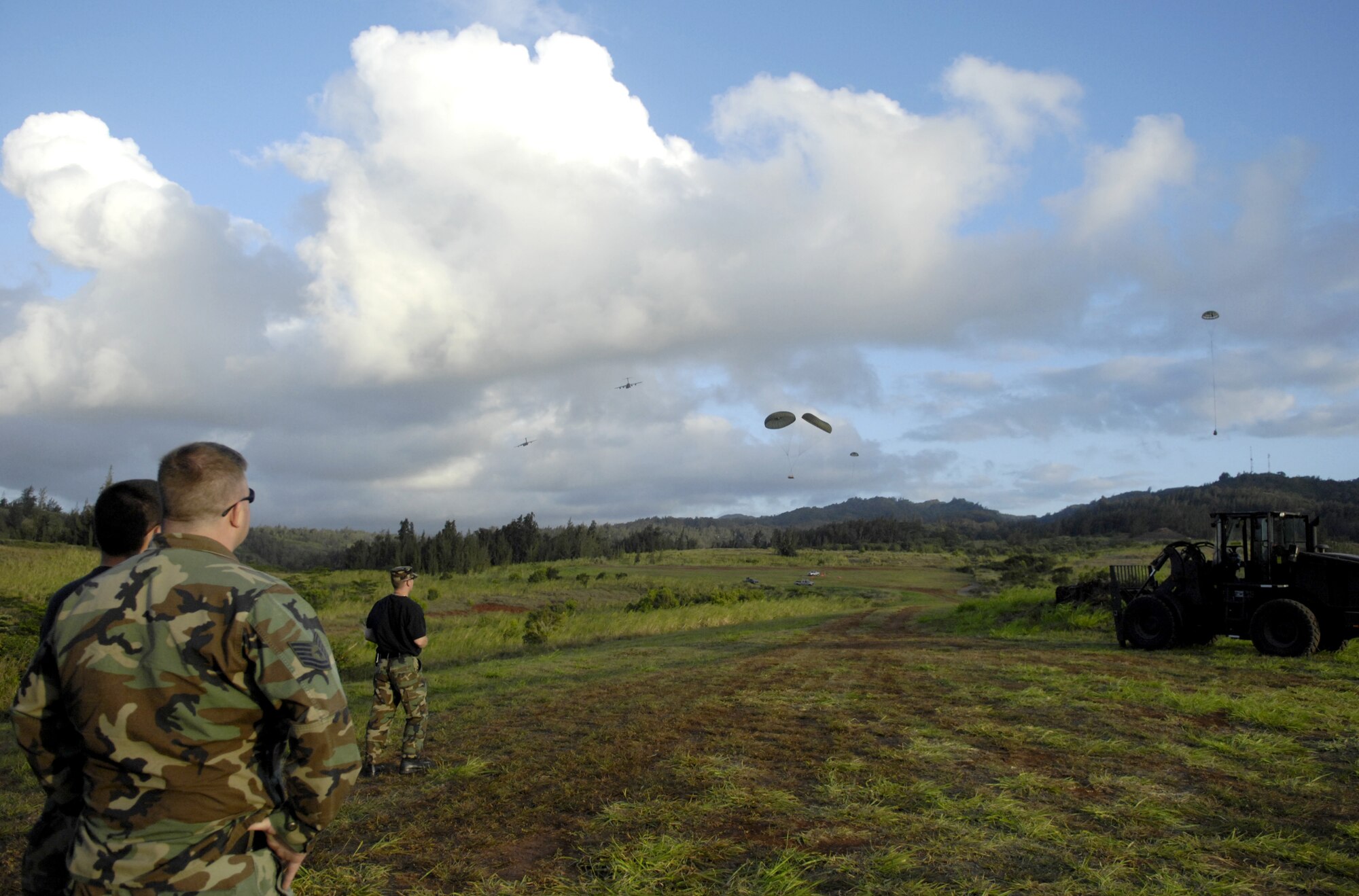 Air Transportation Specialists watch as C-17 Globemaster III’s practice their quarterly airdrop qualifications at the Kahuku Training Range in Hawaii Monday. The Airmen are from the 15th Logistics Readiness Squadron Combat Mobility Element. The C-17’s are from the 535th Airlift Squadron. (U.S. Air Force photo/ Tech. Sgt. Shane A. Cuomo)