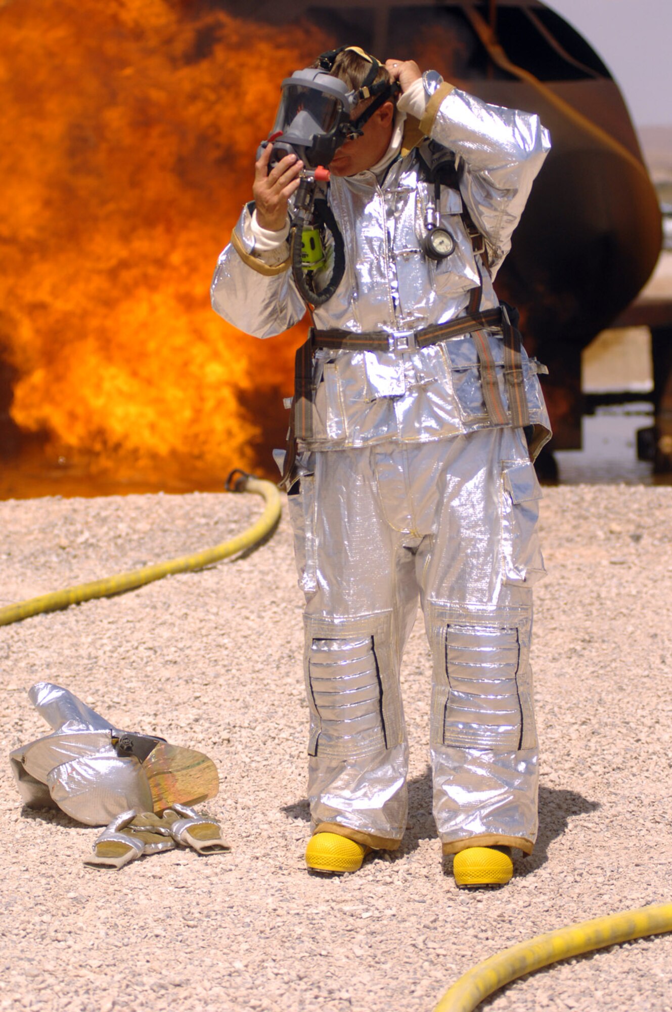 Col. Michael Bartley, 99th Air Base Wing commander, puts his oxygen mask on to prepare for a simulated live fire aircraft training exercise with the firefighters from the 99th Civil Engineer Squadron. Colonel Bartley participated in this training in order to gain an understanding of how the firefighters from the 99th CES train to protect Nellis Air Force Base assets and people. (Photo/Senior Airman Jason Huddleston)