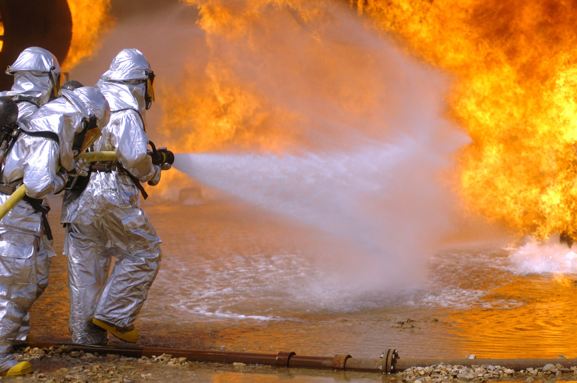 Col. Michael Bartley, 99th Air Base Wing commander, participates in the simulated live fire aircraft training with firefighters from the 99th Civil Engineer Squadron.  Colonel Bartley participated in this training in order to gain an understanding of how the firefighters from the 99th CES train to protect Nellis Air Force Base assets and people. (Photo/Senior Airman Jason Huddleston)