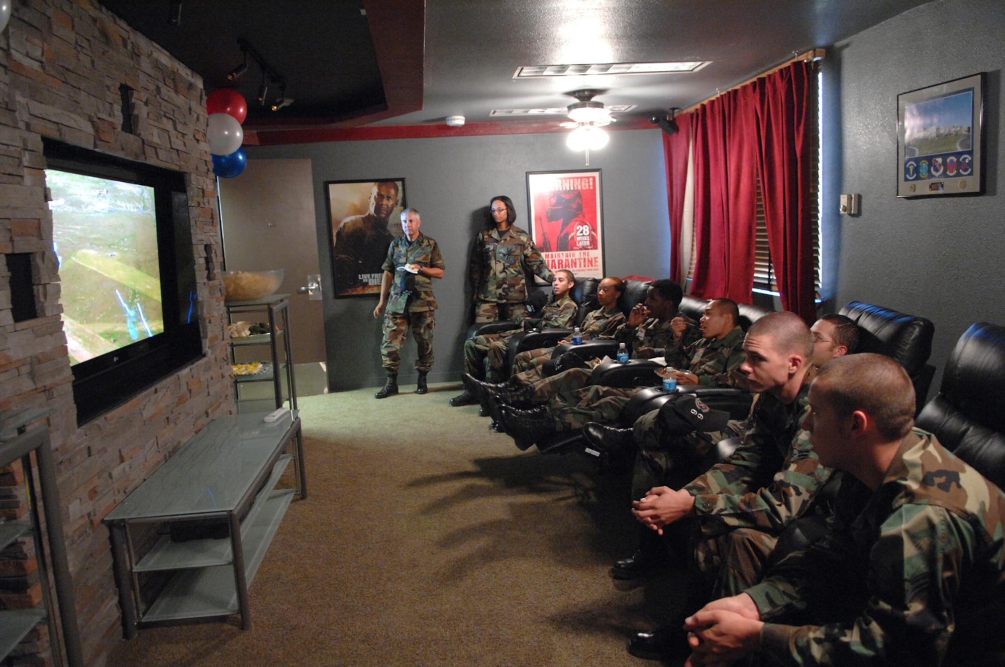 A group of Airmen take a break from duty to catch a movie in the theatre room, which consists of stadium seating, surround sound and a high definition 57 inch flat screen television, inside the new Nellis Airmen's Center June 12.(U.S Air Force Photo/Senior Airman Larry E. Reid Jr.)