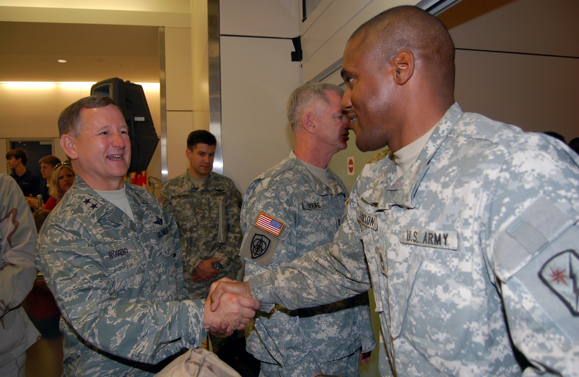 Maj. Gen. Frederick Roggero shakes hands with a Soldier returning from overseas on rest and recuperation leave June 12 at Dallas-Fort Worth International Airport. The general is the director of Air, Space and Information Operations at Headquarters Air Mobility Command. (U.S. Air Force photo/Tech. Sgt. John Jung) 
