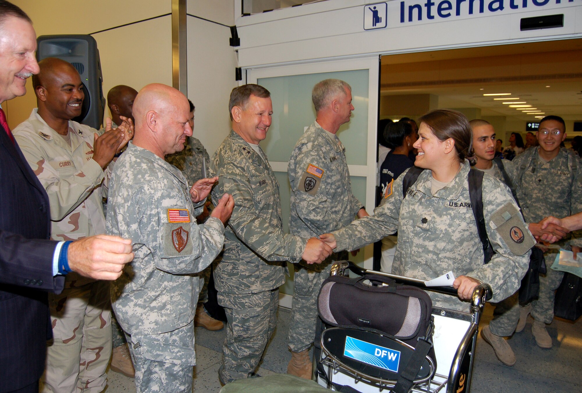 Maj. Gen. Frederick Roggero shakes hands with a Soldier returning from overseas on rest and recuperation leave June 12 at Dallas-Fort Worth International Airport. The general is the director of Air, Space and Information Operations at Headquarters Air Mobility Command. (U.S. Air Force photo/Tech. Sgt. John Jung)
