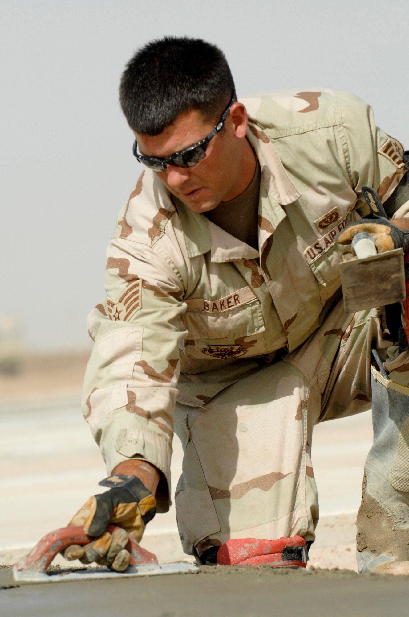 Staff Sgt. James Baker edges and floats freshly poured cement June 11while his team builds a drill pad at Camp Mittica, Iraq. Sergeant Baker is assigned to the 407th Expeditionary Civil Engineer Squadron at Ali Air Base, Iraq. The team is on the Iraqi base constructing a cement drill pad that will be used by the Iraqi army to train their enlisted soldiers. (U.S. Air Force photo/Master Sgt. Robert W. Valenca)