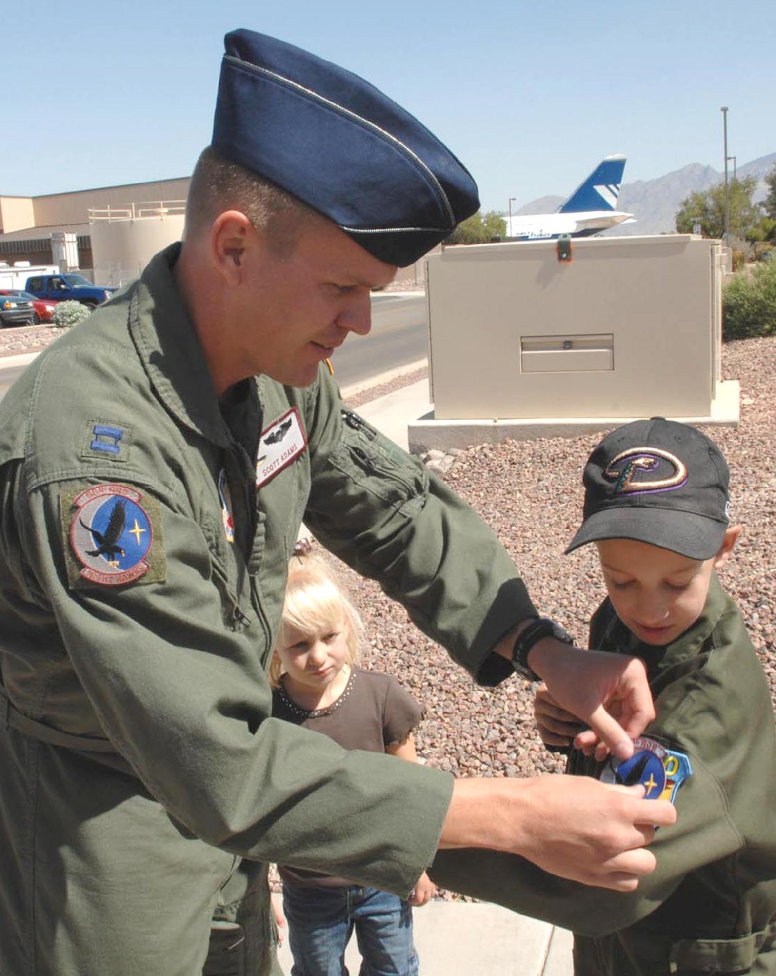 Capt. Scott Adams of the 55th Rescue Squadron here presents Matthew Belleau, 7, with the official 55th RQS patch here June 7. Matthew, the second local child to participate in D-M's Pilot for a Day program so far this year, also received a new flight suit from the 358th Fighter Squadron here, complete with a personalized name tag (U.S. Air Force photo/Airman 1st Class Alesia D. Goosic)