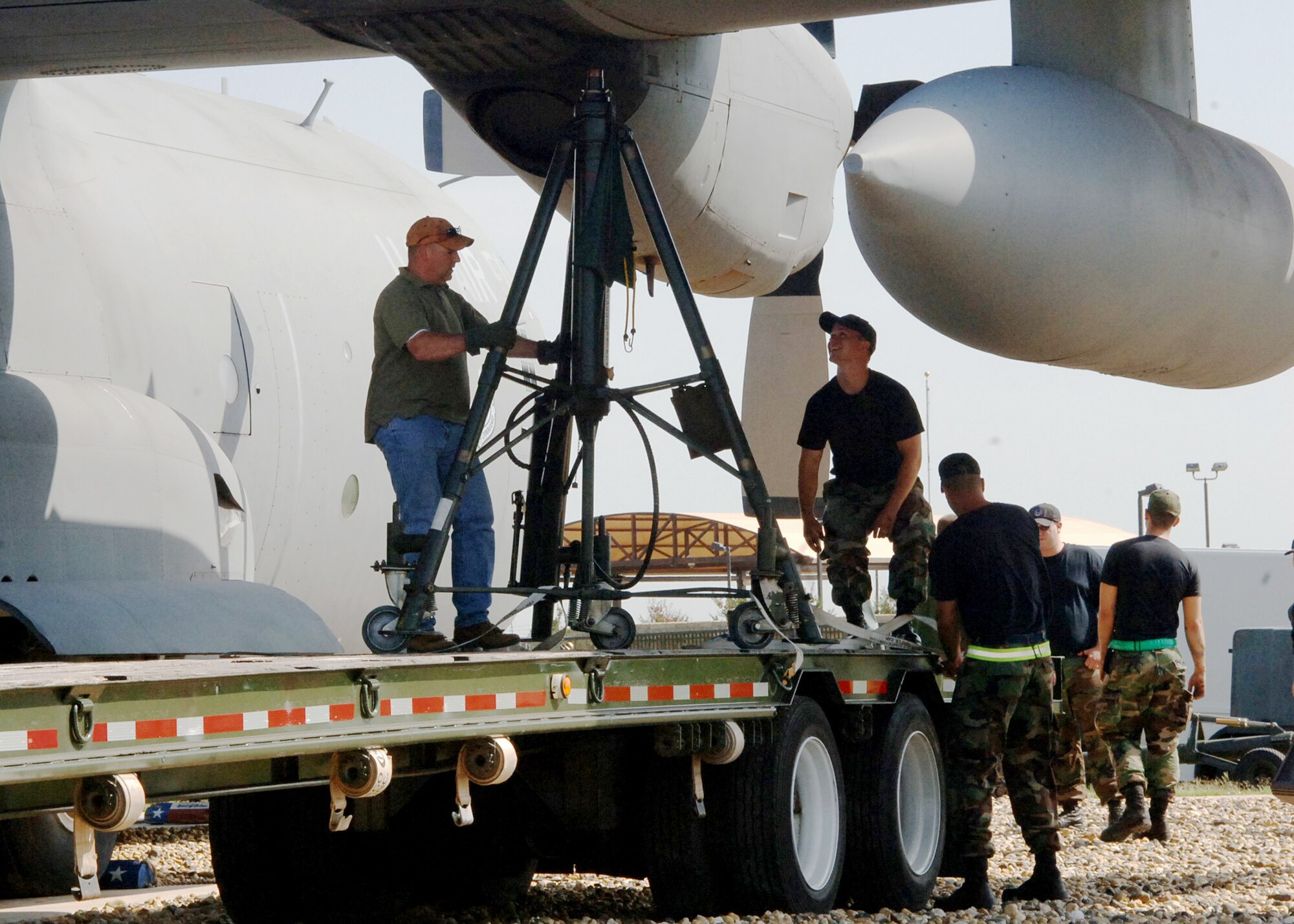 DYESS AIR FORCE BASE, Texas -- Tech. Sgt. Christopher Ellis, 7th Mission Support Squadron, and members of the 317th Aircraft Maintenance Squadron seat a jack to secure a retired C-130 June 11. High winds in the area have moved the static aircraft, displayed at the front gate, approximately three feet over the last several years. (U.S. Air Force photo/Airman 1st Class Felicia Juenke)