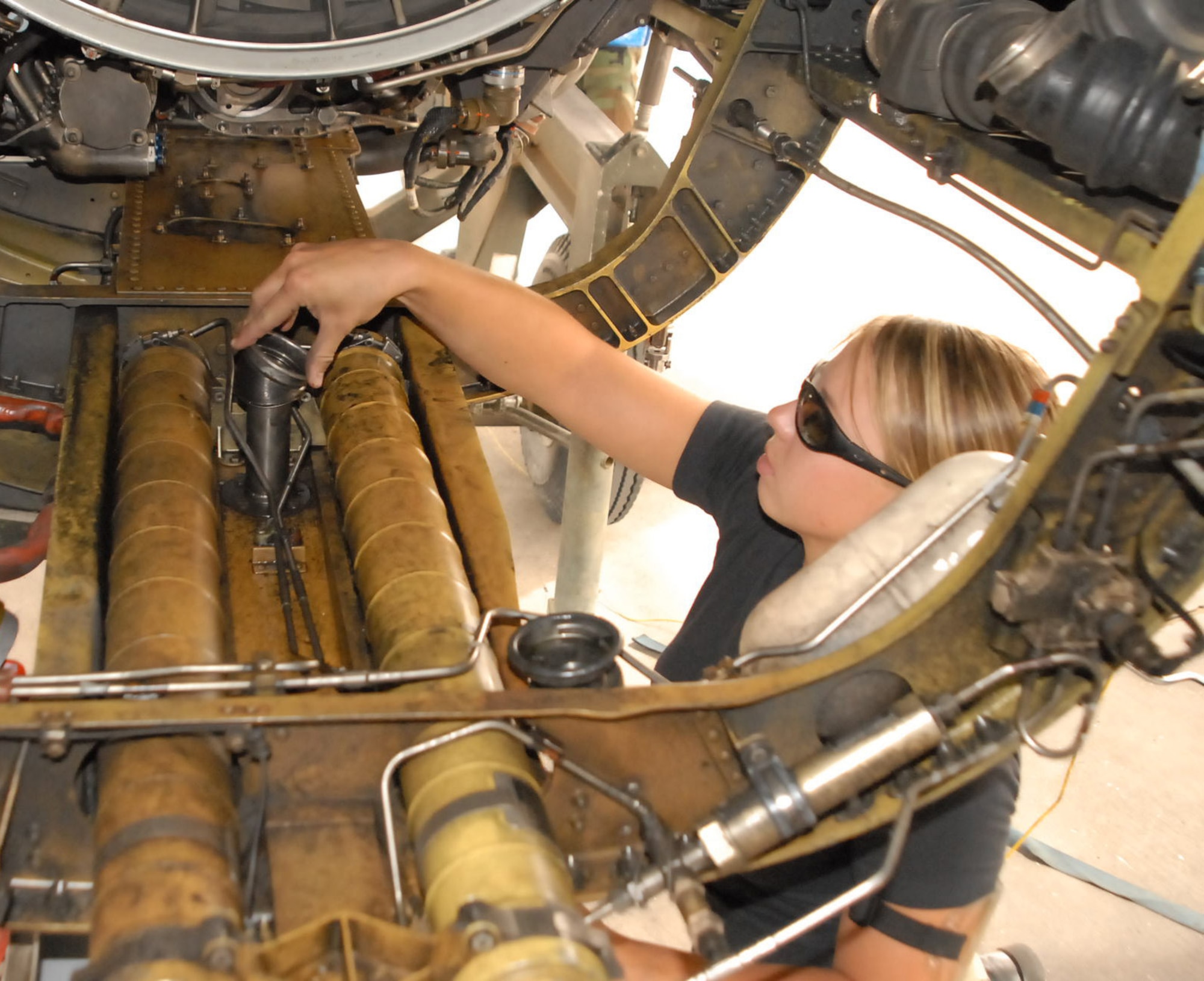 Airman 1st Class Lindsey Simpson, 62nd Aircraft Maintenance Unit assistant dedicated crew chief, removes a bellow adapter Monday from the inside of the engine bay on an F-16 Fighting Falcon. Removing the adapter aids in performing required inspections. Photo by Staff Sgt. Phillip Butterfield
