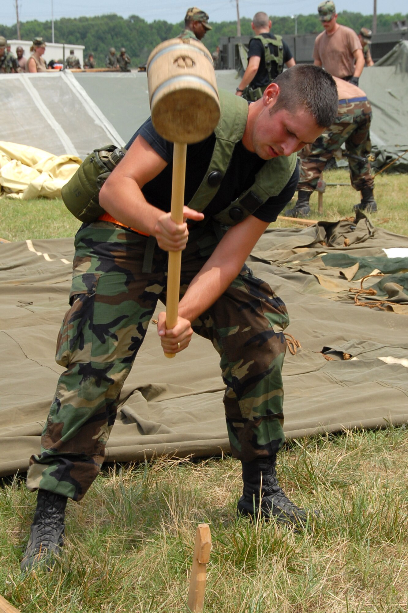 Senior Airman David Foret, a 189th Civil Engineering Squadron structures apprentice, drives a stake into the ground as Guard members construct their tent city during Exercise Hog Heaven.