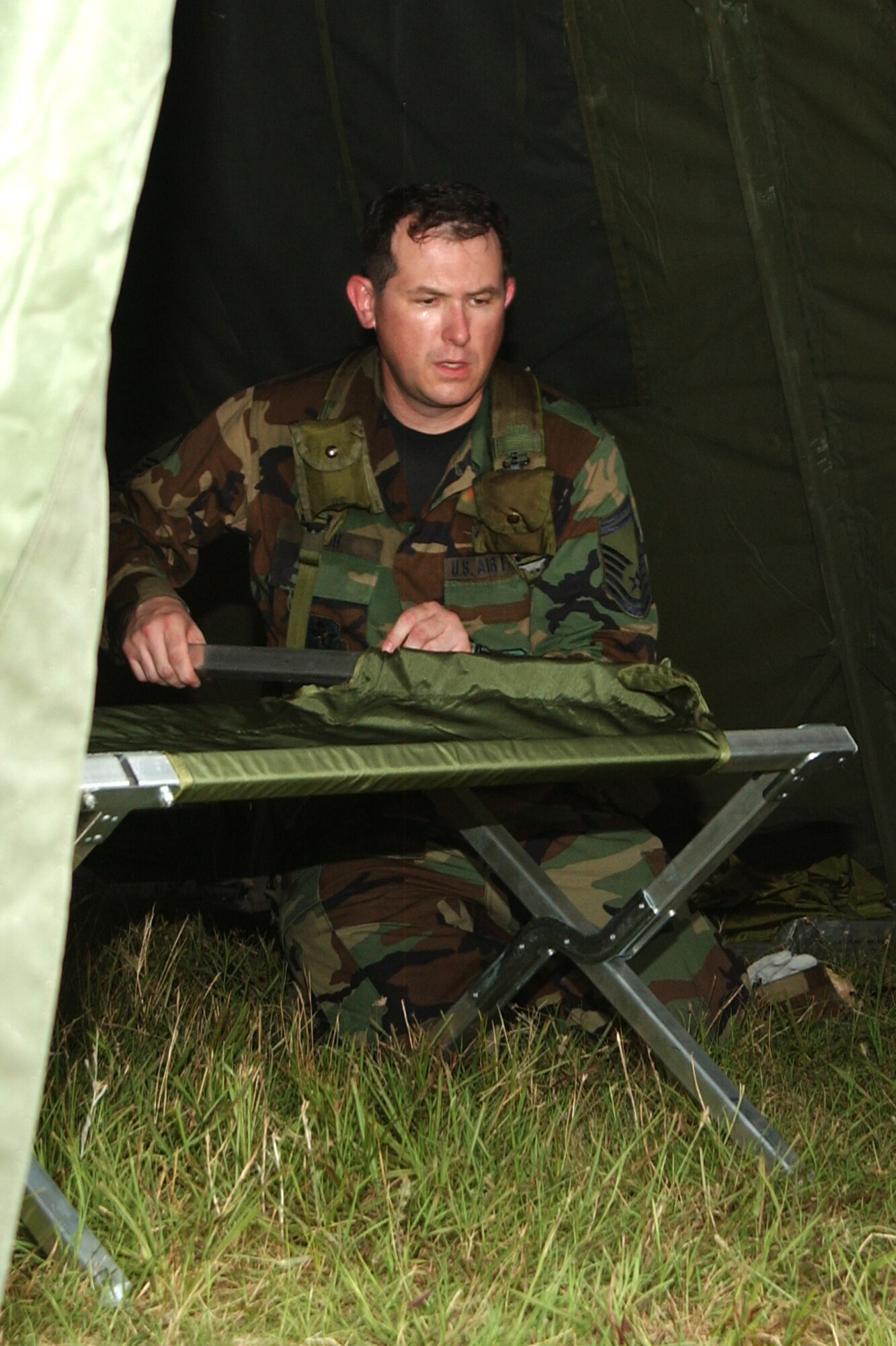 Senior Master Sgt. Gary Ash puts his cot together after a long day in the field on Saturday. (Photo by Master Sgt. Dianna Seerey)