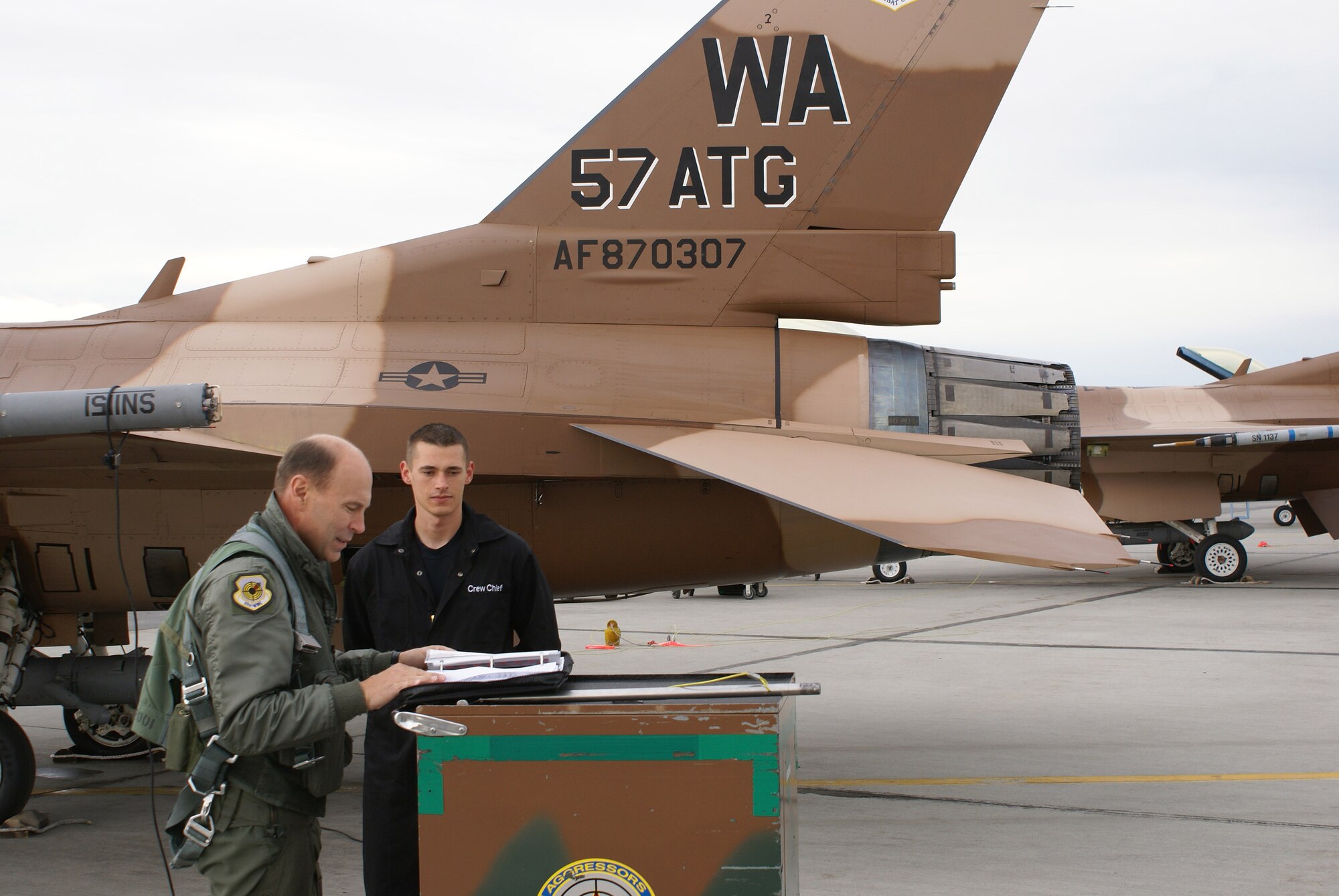 Brig. Gen. William Rew, 57th Wing commander and Senior Airman Richard Kalinowski, 57th Aircraft Maintenance Squadron crew chief, from Nellis Air Force Base, Nev., conduct post-flight checks June 7 on the flightline. General Rew flew as an aggressor during Red Flag-Alaska 07-2 at Eielson AFB. The exercise is designed to give young pilots and aircrew their first 10 combat sorties using the walk-crawl-run approach, stepping up the level of threat and level of difficulty. (U.S. Air Force photo/Master Sgt. Anthony Davis)