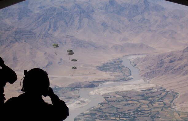 Staff Sgt. Derek Howard, 816th Expeditionary Airlift Squadron evaluator loadmaster, watches cargo bundles fall over a drop zone in Afghanistan.  (U.S. Air Force photo)
