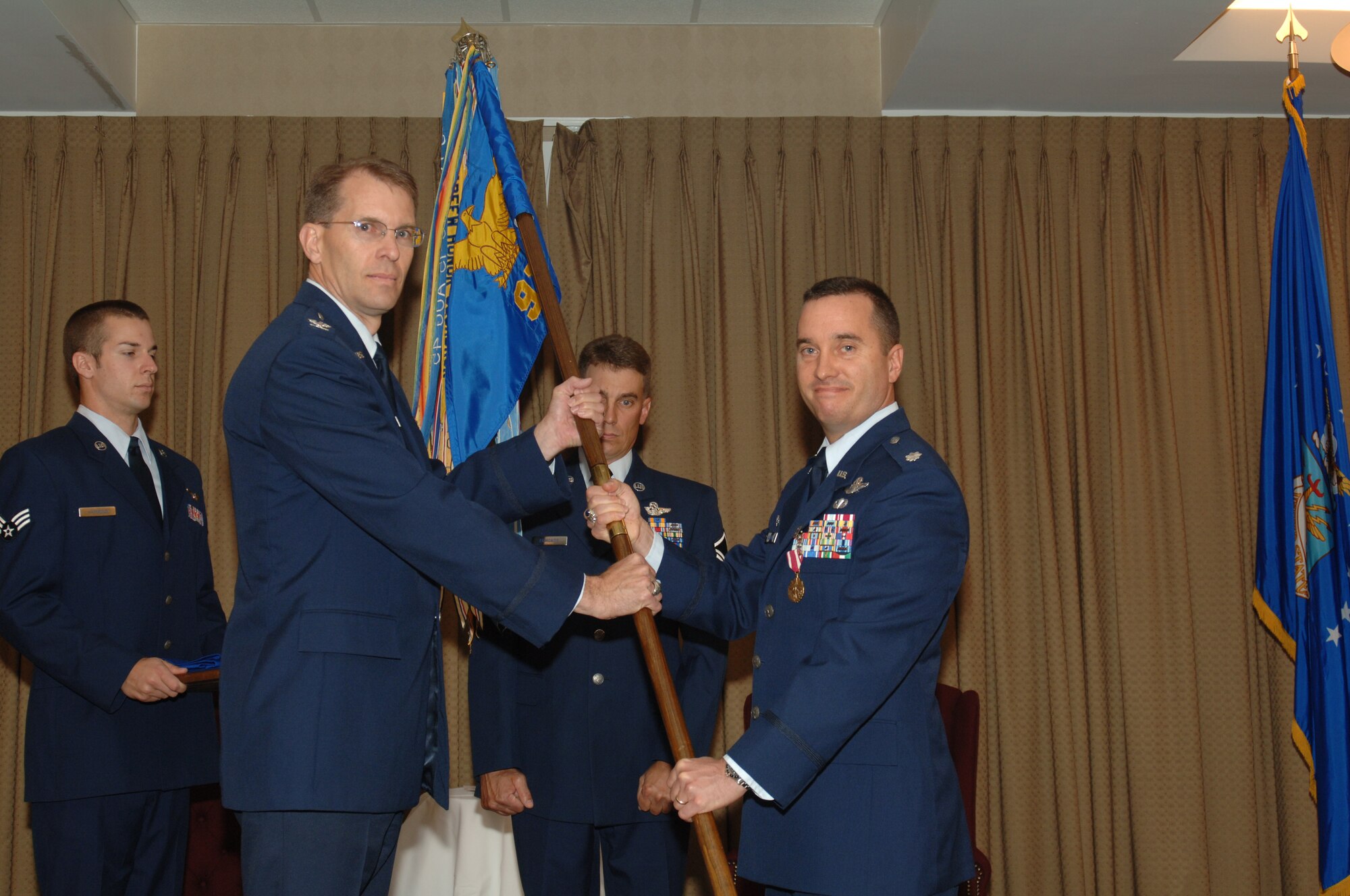 Lt. Col. Patrick Sullivan, 911th Air Refueling Squadron commander, reliquishes the squadron's guidon to Col. Bobby Fowler during a ceremony here June 8. The guidon was sheathed, where it will stay until the 911 ARS reactivates next year under the 916th Operations Group at Seymour Johnson Air Force Base, N.C., as part of Air Force Reserve Command