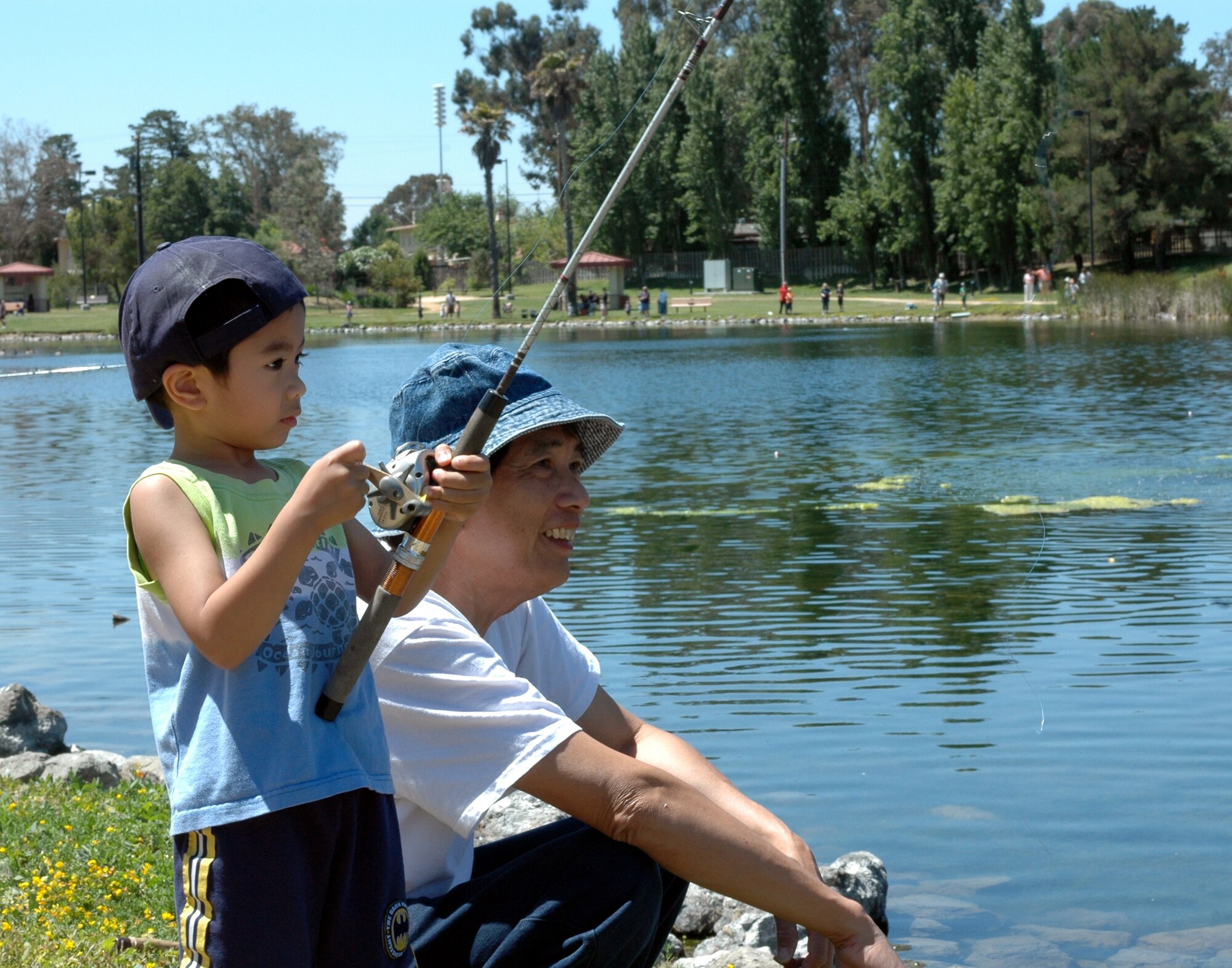K.C. Cadacio, age 4, fishes with his grandfather, Edwin, during the Fishing Derby at the Duck Pond June 9. (U.S Air Force photo by Tech. Sgt. Donald Osborn)