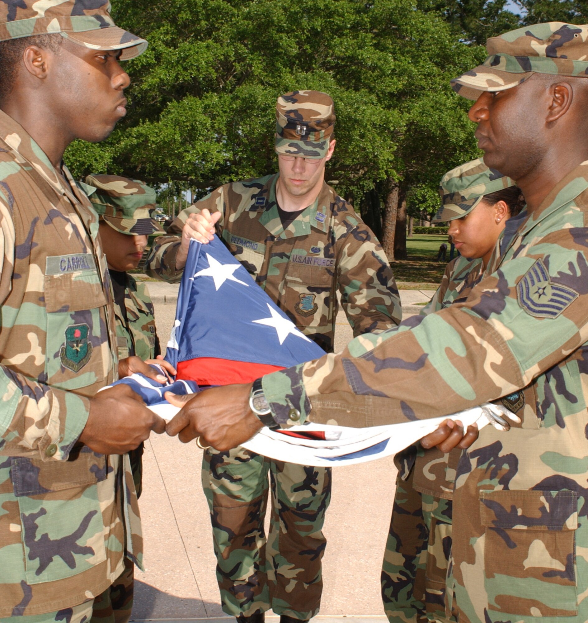 From left, Staff Sgt. Courtney Carroll, Airman Jounel Caceres, Capt. David Redmond, Senior Airman Tomeka Jackson and Tech. Sgt. Quardrick Brumfield fold the flag at the 81st Training Wing’s formal retreat, May 17.  Sergeant Carroll and Captain Redmond are from the legal office, Airmen Caceres and Jackson are from the chapel and Sergeant Brumfield is from the exercise evaluation team.  (U. S. Air Force photo by Kemberly Groue)