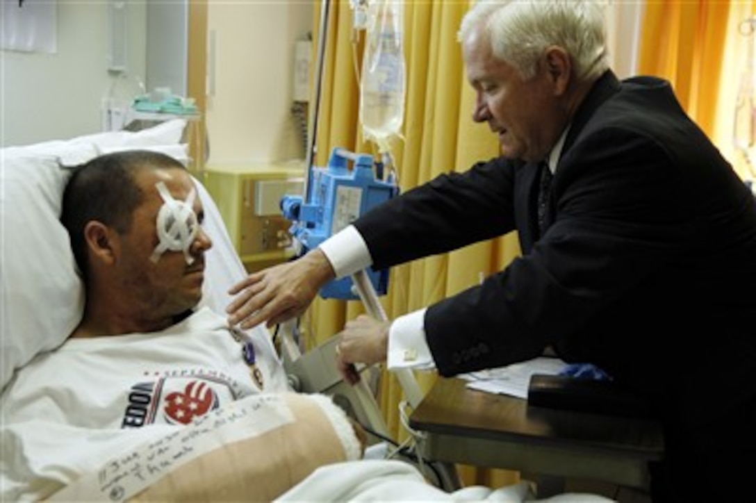 Secretary of Defense Robert M. Gates presents the Purple Heart medal to U.S. Army Staff Sgt. Brent A. Homan for wounds received in action, June 11, in Balad, Iraq. Gates visited several military members at Landstuhl Regional Medical Center in Germany, June 13, 2007. 