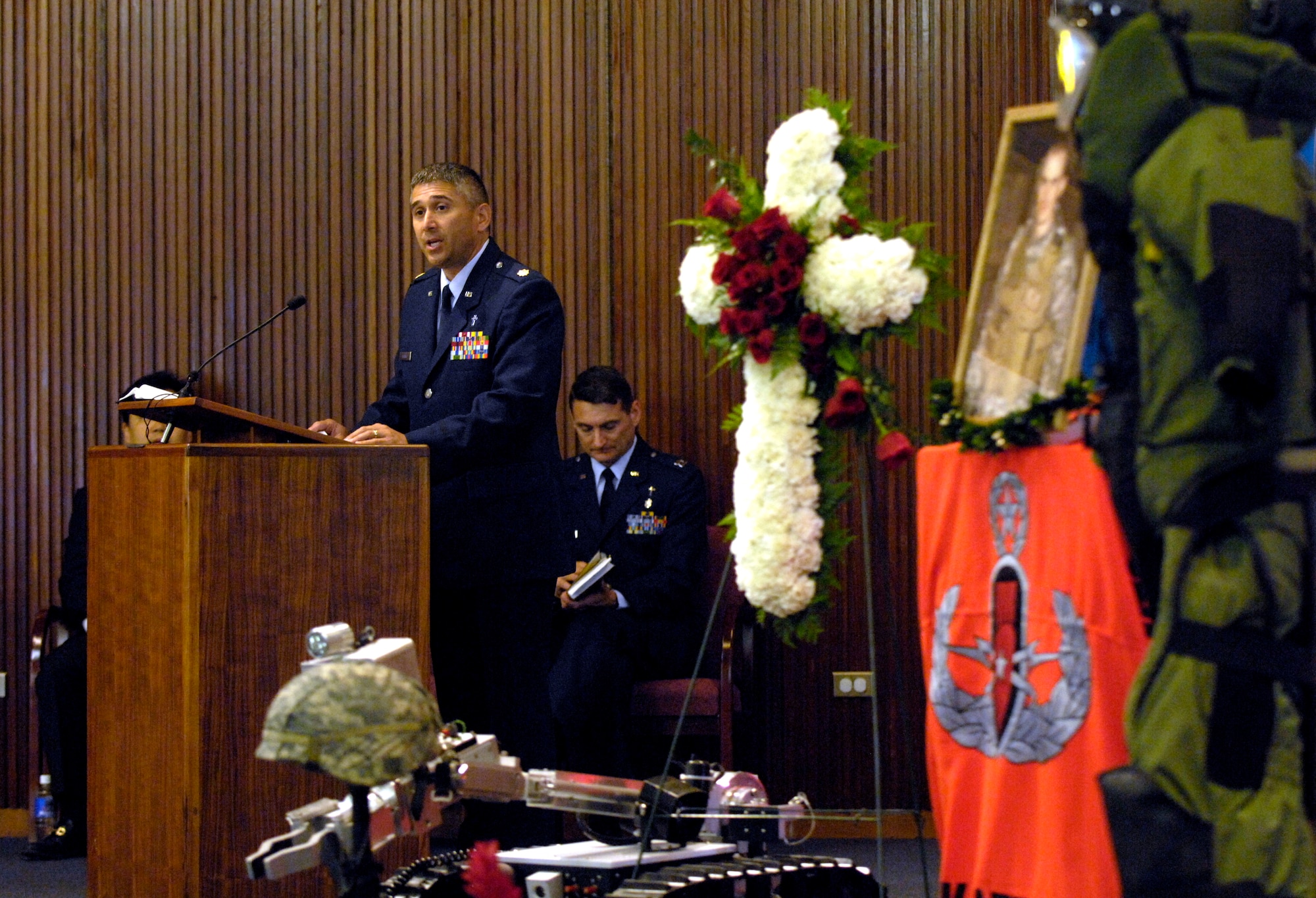Ch. Maj. Dave DePinho, 15th Airlift Wing chaplain, reads the scripture during a memorial service honoring Senior Airman William Newman at the base chapel at Hickam June 13. Airman Newman, an explosive ordnance disposal technician assigned to the 15th Civil Engineer Squadron, was killed June 7 by an improvised explosive device, which detonated while he was supporting Army and Iraqi security forces near the village of Mishna, Iraq. (U.S. Air Force photo by Tech. Sgt. Shane A. Cuomo)