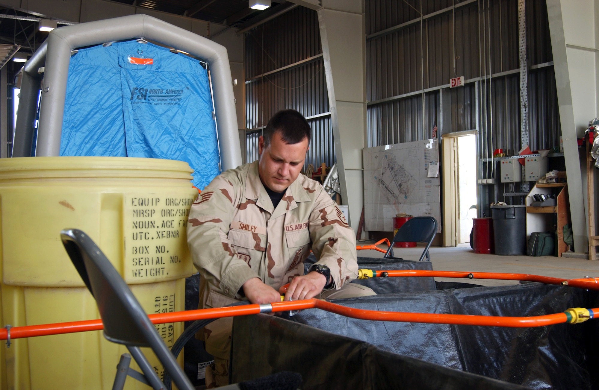 Staff Sgt. Chris Smiley sets up a hazardous-material decontamination line June 5 for a training exercise at Balad Air Base, Iraq.  Sergeant Smiley is a firefighter with the 332nd Expeditionary Civil Engineer Squadron Fire and Emergency Services Flight.  (U.S. Air Force photo/1st Lt. Shannon Collins)