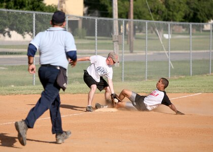 Third baseman Nicholas Miller from the 701st Military Police Battalion tags out Jose Carino from the Defense Language Institute during Division II intramural softball action June 11 at Diamond 3 on Lackland Air Force Base, Texas. The 701st won, 14-2. (USAF photo by Robbin Cresswell)