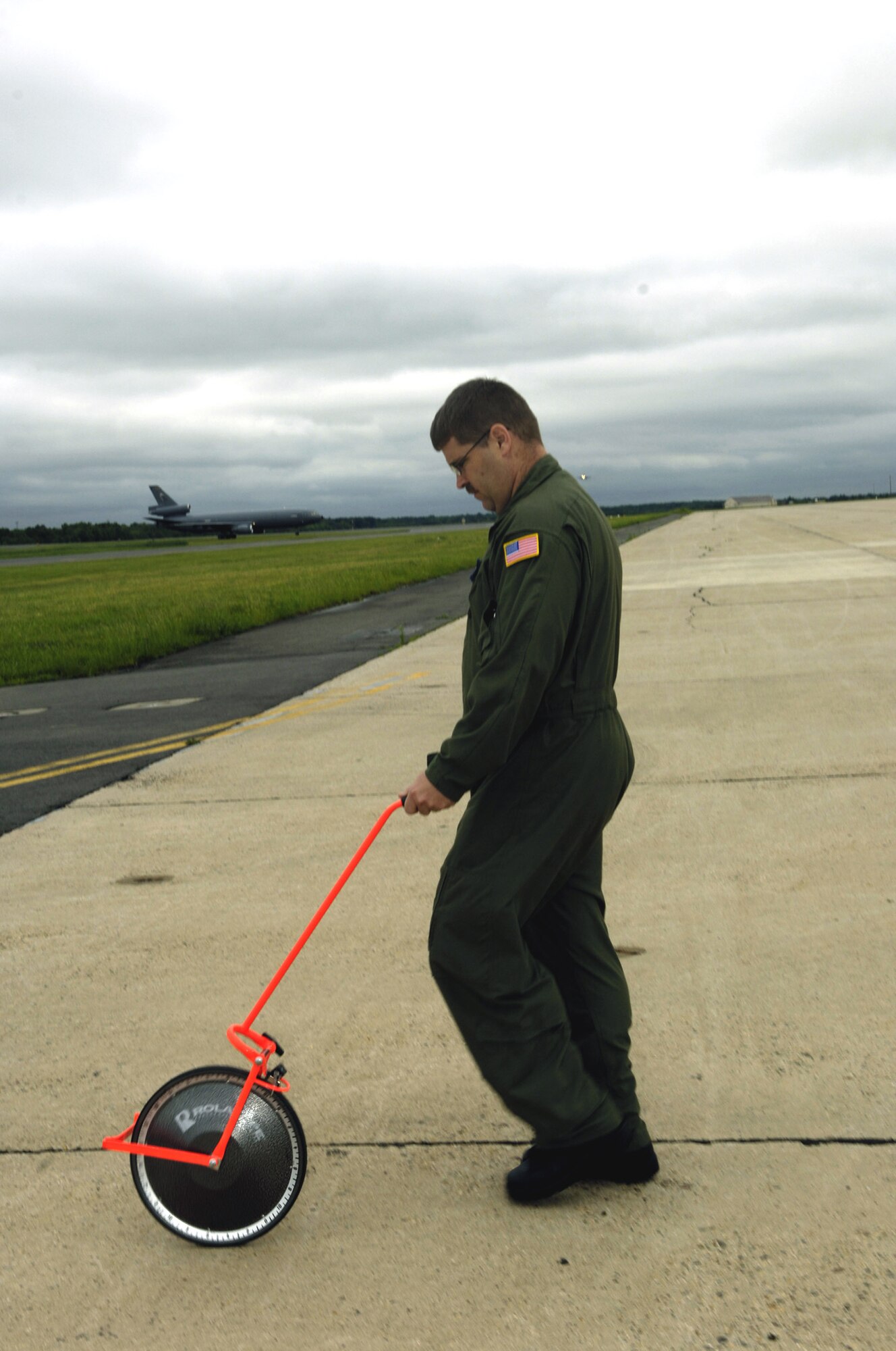 Master Sgt. Michael Deehr uses a measuring wheel on the flightline at McGuire Air Force Base, N.J., during an airfield survey exercise June 4 for the Mobility Air Forces Mobile Command and Control Leadership Course.  Sergeant Deehr is with the 819th Global Support Squadron at McGuire AFB.  (U.S. Air Force photo/Ken Mann)