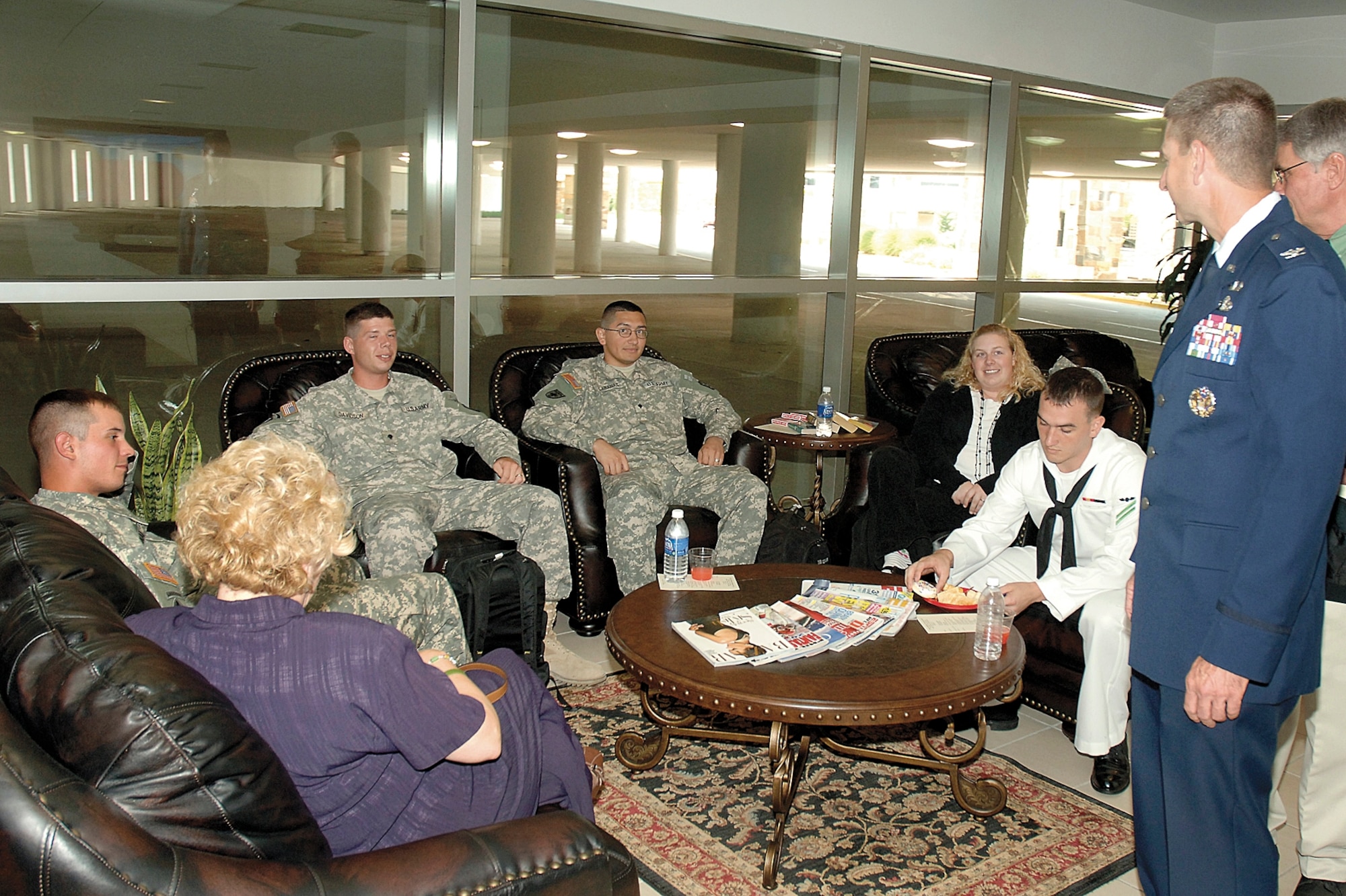 After grand opening ceremonies June 5, 72nd Air Base Wing Commander and Tinker Installation Commander Col. Mark Correll, standing, visits with Soldiers and Sailors relaxing in the Military Welcome Center at Will Rogers World Airport.  Col. Correll, 552nd Air Control Wing Vice Commander Col. Jeffrey Beene and VQ-3 Executive Officer Cmdr. Jeffrey Marshall helped cut the grand opening ribbon with other military and civic leaders. (Air Force photo by Margo Wright)