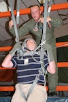 Staff Sgt. Kenneth Walter, 28th Bomb Wing Survival, Evasion, Resistance and Escape specialist, guides David Harris, Schertz City Hall assistant city manager, on how to free himself from a parachute and lower himself to the ground. Mr. Harris and 26 other local civic leaders joined Col. Richard Clark, 12th Flying Training Wing commander, on a two-day tour of Ellsworth AFB, N.D., and Nellis AFB, Nev. (Photo by Senior Airman Tim Bazar)