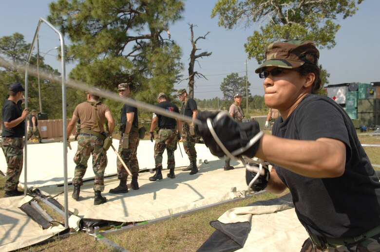 Tech. Sgt. Petula Moithukshung, 106th Medical Group, Gabreski AFB, NY, assists in constructing an Alaskan Medical Shelter by using rope to pull the roof cover into place during Golden Medic 2007. Golden Medic is a yearly medical exercise sponsored by the U.S. Army designed to provide a realistic training experience to participating combat support and service support units, while enhancing the overall training and readiness of Army and Air Force medical units. (U.S. Air Force photo/Senior Airman Erica J.Knight)