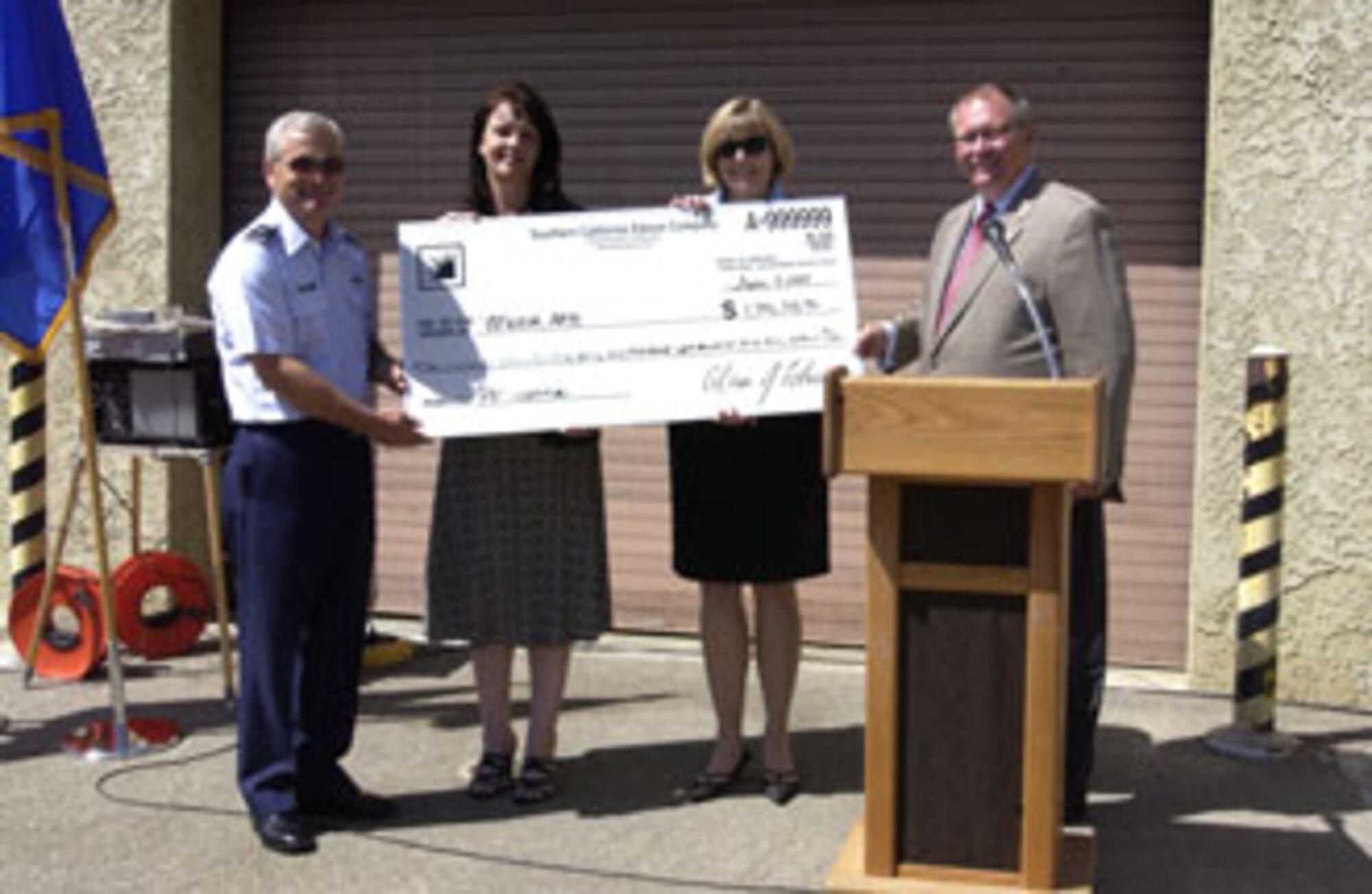 John King from Southern California Edison (right) presented a rebate check for over $1 million dollars to the 452nd Air Mobility Wing Commander, Brig. Gen. James Melin (left), for reducing power demand using a renewable energy source through SCE’s power generation rebate program at the official ribbon cutting ceremony June 7. At a cost of $4,600,000, it is the largest renewable energy system installed to date by the Air Force and will generate enough power to operate two facilities and back feed excess power to the March ARB grid. Annual energy savings are estimated at $213,214 with an additional savings of $38,382 for demand charges. The project was coordinated and implemented by the 452nd Civil Engineers. (U.S. Air Force photo by Amy Abbott)