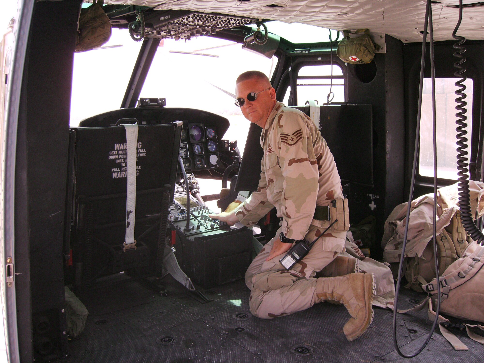 Iraq -- SSgt. Brian Pittman examines the avionics in a UH-1 Huey helicopter. SSgt. Pittman is part of the 916th Air Refueling Wing, Seymour Johnson AFB, NC, Air Force Reserve. He is currently serving overseas helping Iraqi Air Force members learn about aircraft maintenance. 