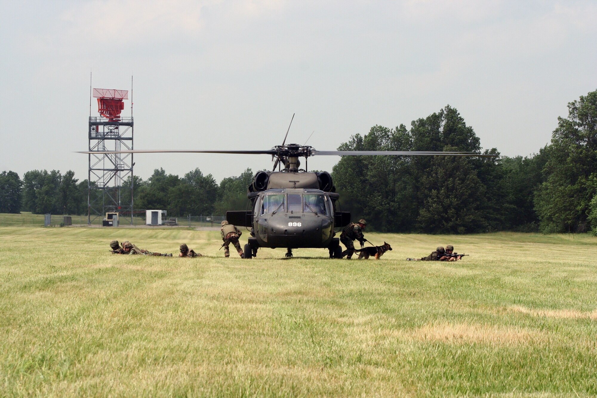 Members of the 509th Explosive Ordnance Disposal flight and Security Forces Squadron unload from a UH-60 Blackhawk June 7 during a week-long training scenario here. Part of a Joint Service training operation, the 1-106 Aviation Assault Battalion from Fort Leonard Wood provided the helicopter to give Airmen a more realistic experience. (U.S. Air Force photo/Staff Sgt. Jason Barebo)