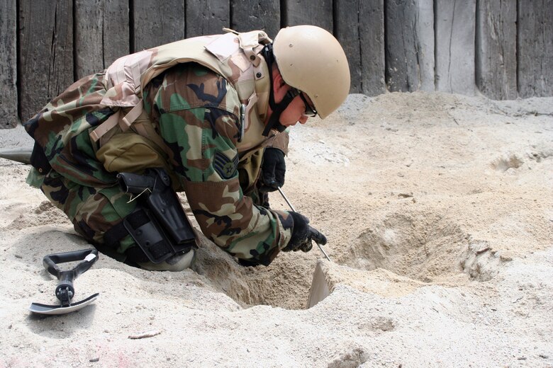 Staff Sgt. Kenneth Westrum, 509th Explosive Ordnance Disposal flight, unearths an improvised explosive device June 7 during a week-long training scenario here. The training was conducted to better prepare Airmen for real world scenarios during deployments. (U.S. Air Force photo/Staff Sgt. Jason Barebo)