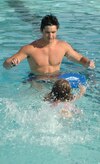 Mr. Noble, life guard and swim instructor, encourages Maci Henderson, 7, to swim toward him to improve her kick at the base pool June 12.  (U.S. Air Force photo/ Staff Sgt. April Quintanilla) 