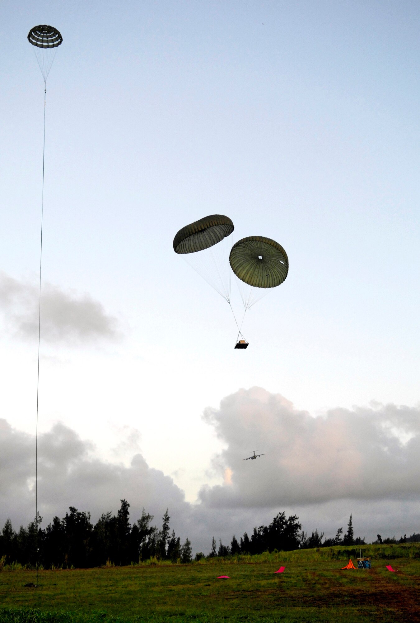 Practice airdrop bundles come in for a landing June 11 at the Kahuku Training Range in Hawaii. The bundles were dropped from C-17 Globemaster IIIs from the 535th Airlift Squadron at Hickam Air Force Base who are conducting their quarterly airdrop qualifications. (U.S. Air Force photo/ Tech. Sgt. Shane A. Cuomo) 