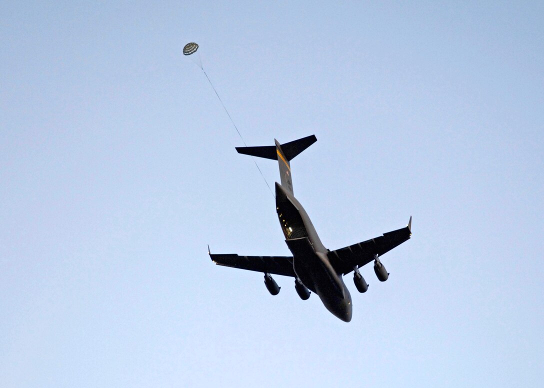 During an airdrop qualification, a practice bundle is dropped from a C-17 Globemaster III June 11 at the Kahuku Training Range in Hawaii. The C-17s are from the 535th Airlift Squadron at Hickam Air Force Base, Hawaii. (U.S. Air Force photo/ Tech. Sgt. Shane A. Cuomo)