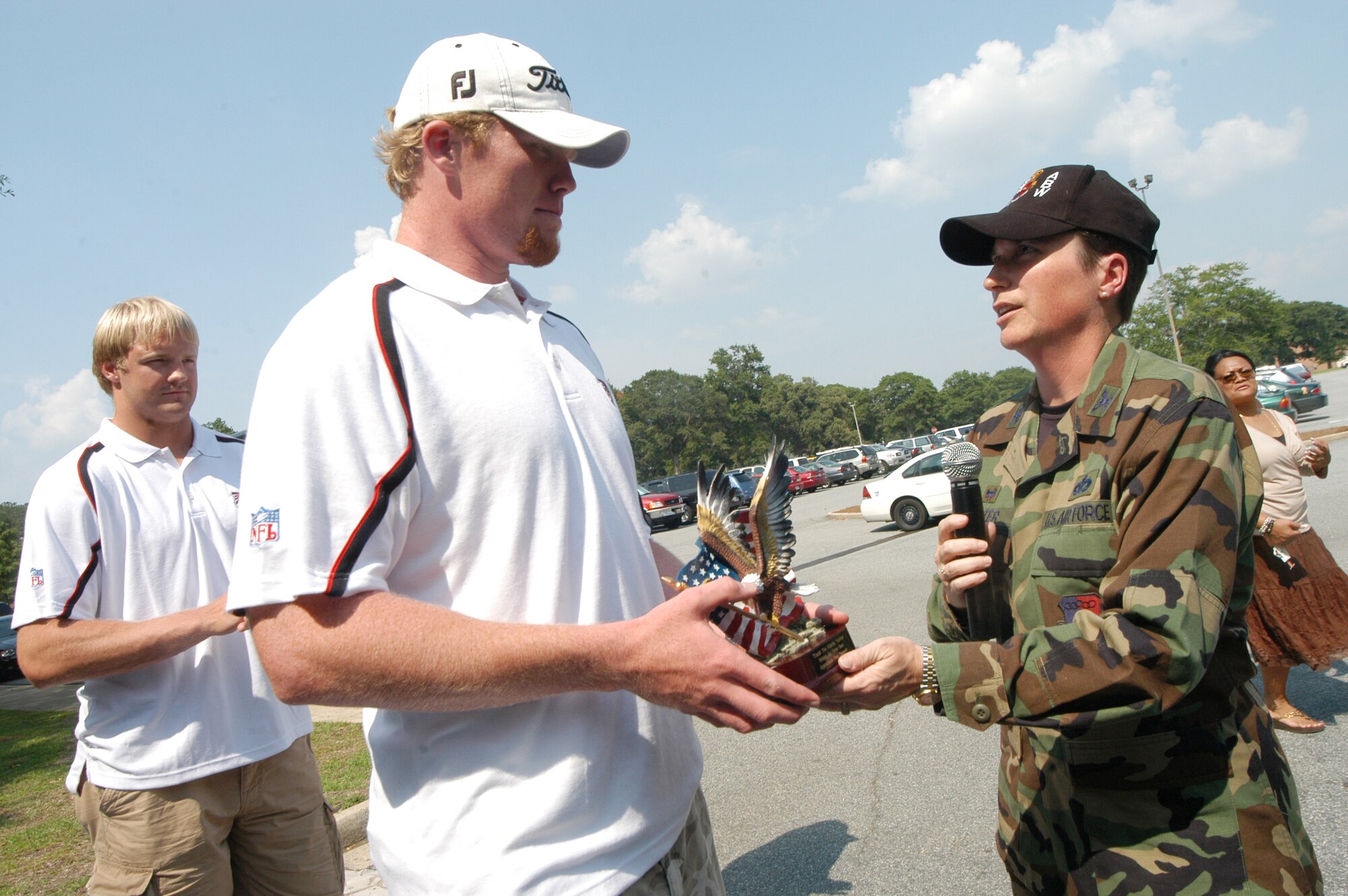 Boone Stutz, long snapper with the Atlanta Falcons, accepts an eagle from Col. Theresa Carter, 78th Air Base Wing commander at FalconFest Monday. U. S. Air Force photo by Sue Sapp    