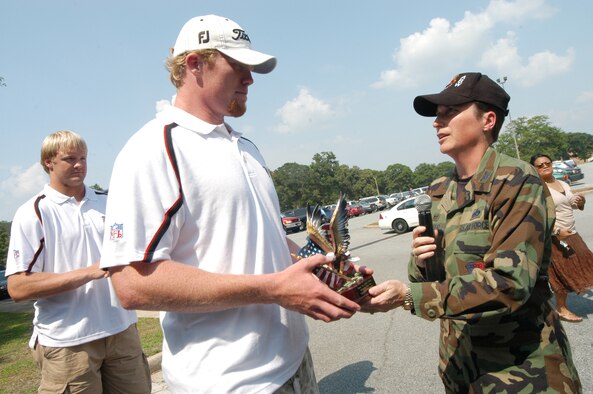 Boone Stutz, long snapper with the Atlanta Falcons, accepts an eagle from Col. Theresa Carter, 78th Air Base Wing commander at FalconFest. (Air Force photo by Sue Sapp)