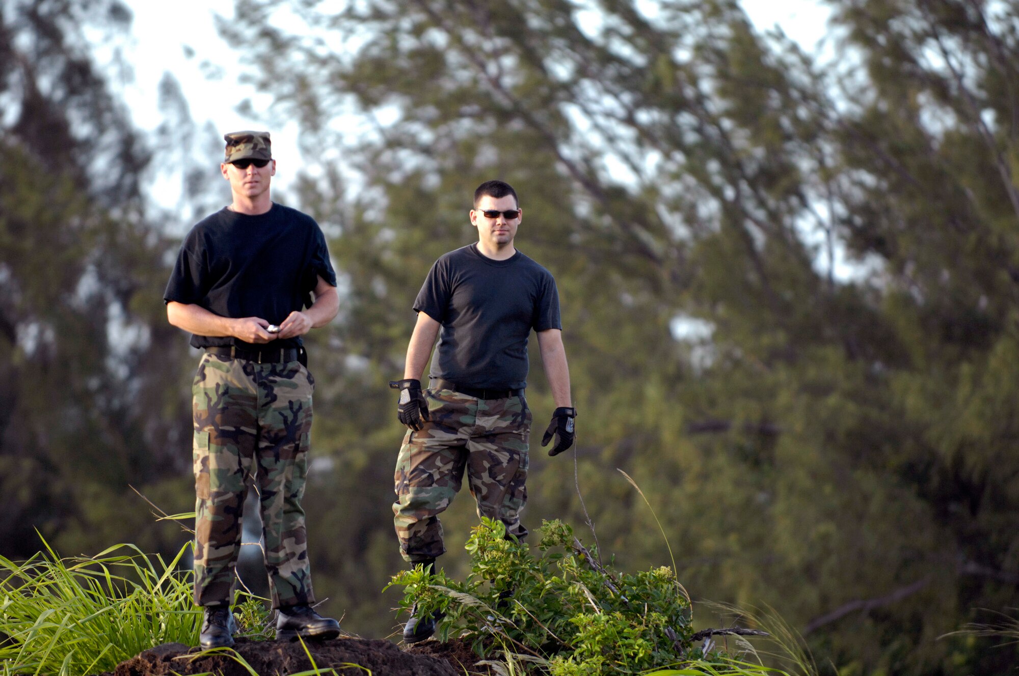 Staff Sgt. Robert Ward and Airman 1st Class Justin Stevens watch the 535th Airlift Squadron's C-17 Globemaster IIIs run quarterly airdrop qualifications June 11 at the Kahuku Training Range in Hawaii. The Airmen who had loaded the cargo bundles are from the 15th Logistics Readiness Squadron Combat Mobility Element and the C-17s are from Hickam Air Force Base, Hawaii. (U.S. Air Force photo/ Tech. Sgt. Shane A. Cuomo) 