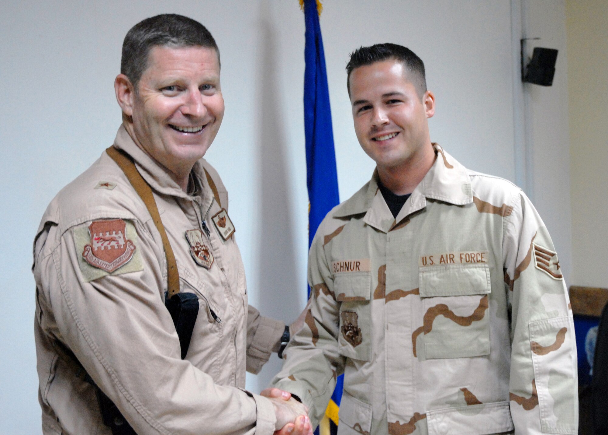 Brig. Gen. Robin Rand, 332nd Air Expeditionary Wing commander, congratulates Staff Sgt. Timothy R. Schnur (right) the Balad Air Base Tuskegee Airman of the week for June 1-7, 2007. Deployed from Sheppard Air Force Base, Texas, Sergeant Schnur is a pharmacy technician instructor with the 332nd Expeditionary Medical Support Squadron. Sergeant Schnur was selected for his outstanding professionalism in pharmacy support of the Air Force Theater Hospital, the most advanced and effective trauma center ever deployed into a combat zone. (U.S. Air Force photo / Maj. Robert Couse-Baker)
