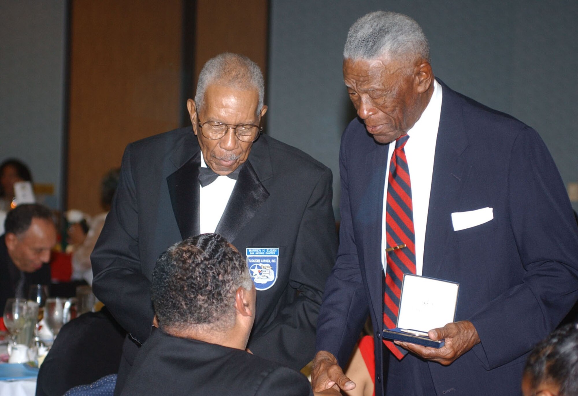 Tuskegee Airmen Warren Eusan (left) and John Miles talk with audience members after receiving bronze replicas of the Congressional Gold Medal that was presented to all Tuskegee Airmen earlier this year in recognition of their service and sacrifice to the United States during World War II. The local heroes were presented the medals June 9 as part of the San Antonio Chapter, Tuskegee Airmen Inc.'s 16th Annual Education Assistance Awards Banquet. (U.S. Air Force photo by Staff Sgt. Lindsey Maurice)