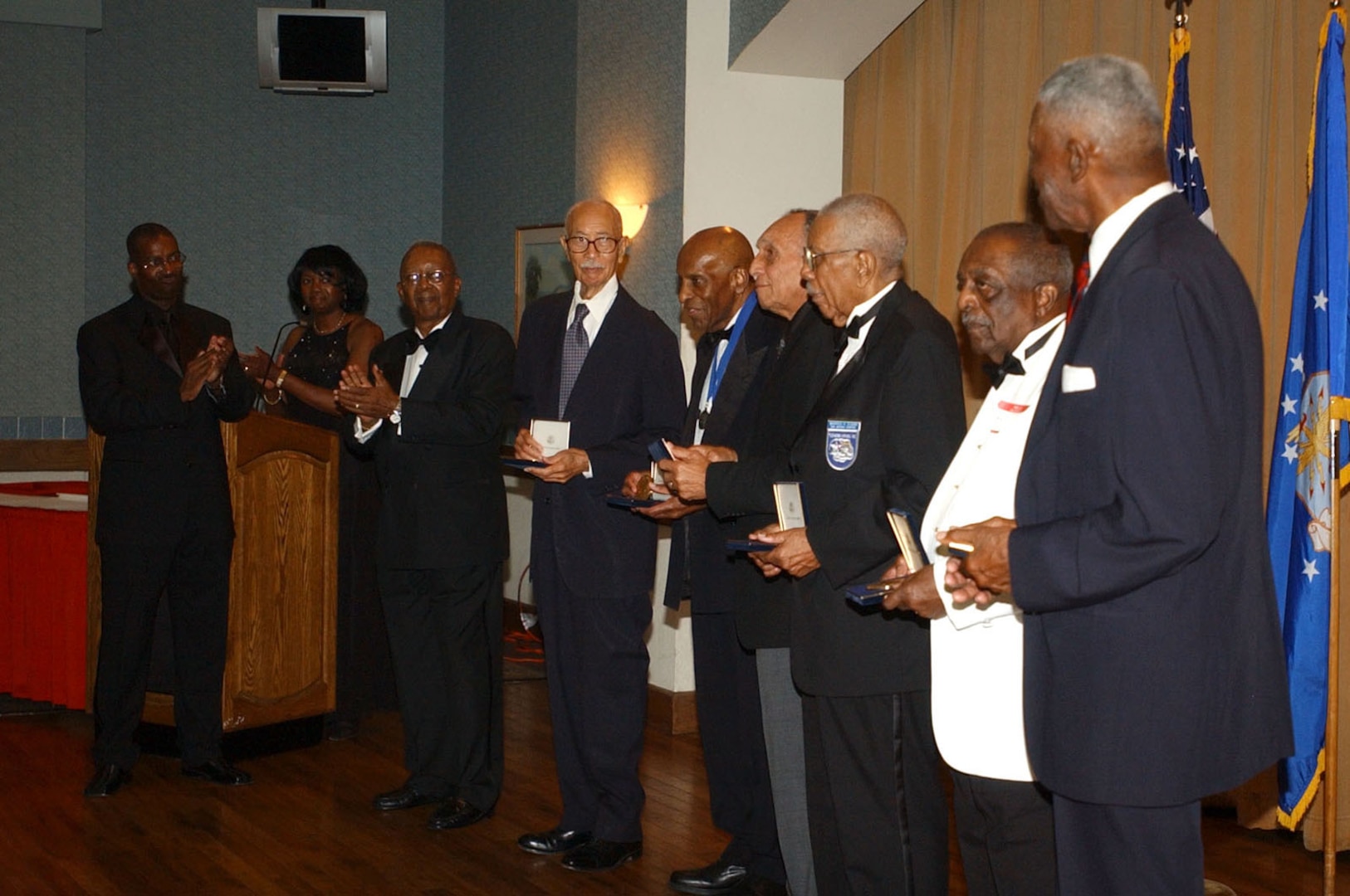 San Antonio Chapter Tuskegee Airmen Inc. members (left) applaud local Tuskegee Airmen (from left to right) Matthew Plummer, Dr. Granville Coggs, Dr. Eugene Derricotte, Warren Eusan, William Gray and John Miles after presenting them with  bronze replicas of the Congressional Gold Medal that was presented to all Tuskegee Airmen earlier this year in recognition of their service and sacrifice to the United States during World War II. The presentation was part of the local chapter's 16th Annual Education Assistance Awards Banquet held June 9. (U.S. Air Force photo by Staff Sgt. Lindsey Maurice)
                   