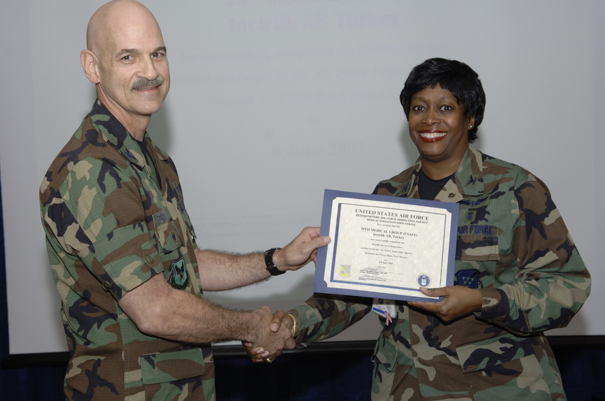 Col. Garry Forthman, Air Force Inspection Agency Health Service Inspection team chief, presents Col. Kimberly Cox, 39th medical group with a certificate that states the MDG received an overall "Excellent" rating.  (U. S. Air Force photo by Airman 1st Class Nathan W. Lipscomb)
