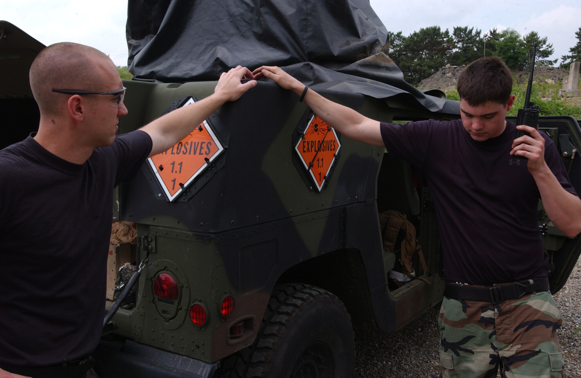 OSAN AIR BASE, Republic of Korea -- (left) Staff Sgt. Ben Ford and Senior Airman Mike LaFranca, 51st Civil Engineering Squadron, radio in a notification message before detonating a charge of Composition C4.  Sergeant Ford and Senior Airman LaFranca were practicing demolition procedures with several other airmen from Osan's Explosive Ordinance Disposal team. (U.S. Air Force by A1C Jason Epley)
