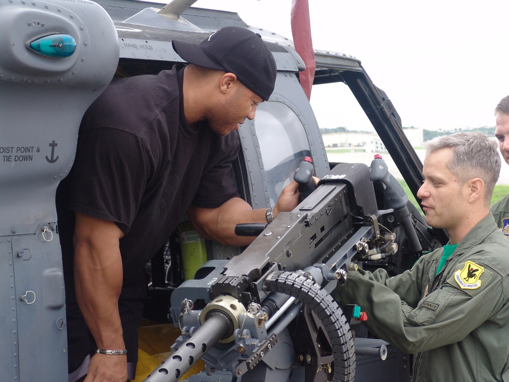 Tech. Sgt. Jerrod Morse briefs Phil Heath on .50-Caliber machine gun helicopter operations in front of a HH-60G rescue helicopter during his tour of the 33rd Rescue Squadron June 8. Mr. Heath was the guest poser at the 2007 Pacific Muscle Classic held at Kadena Air Base, Japan, June 10. 
(U.S. Air Force courtesy photo)                               
